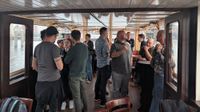 A bunch of people inside of a canal boat in Amsterdam having a chat