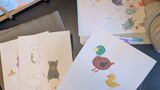 A bunch of drawings, includes a duck and mouse in a cute manner, next to it you see a child's arms drawing/colouring some cute animals
